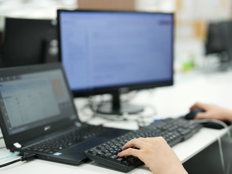 ノートパソコンを操作する社員の手元