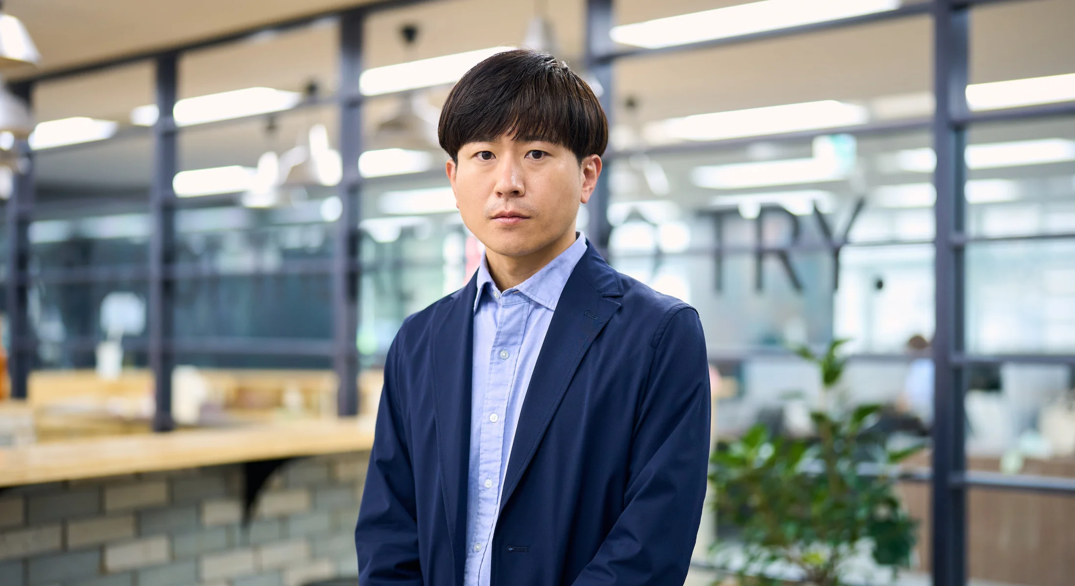 社内のカフェスペースに立つ人事本部の部長