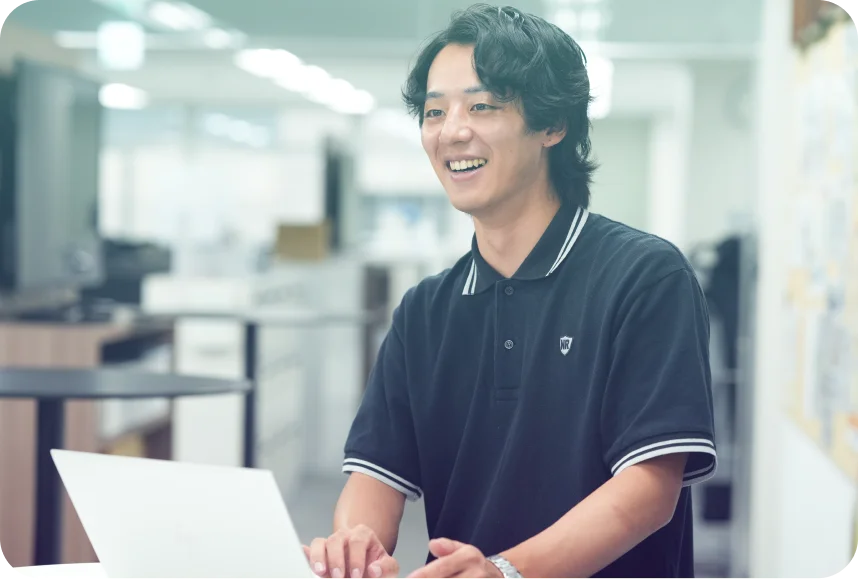 ノートパソコンを操作しながら話す社員